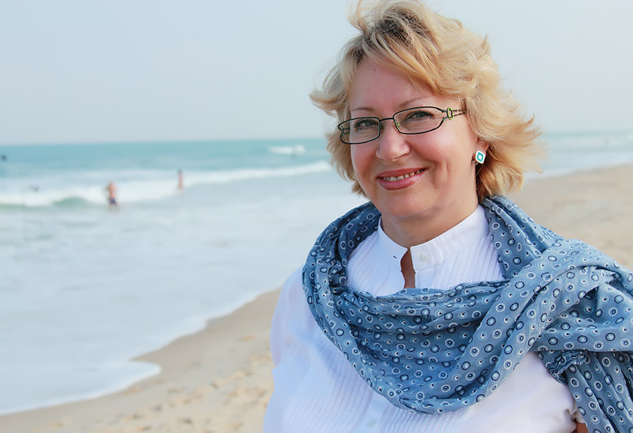 Photograph of a wealthy lady walking on the beach